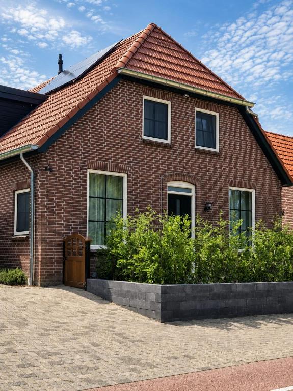 a red brick house with a brown roof at 'tNest Middelaar in Middelaar
