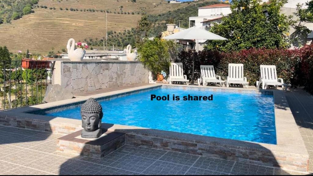 a swimming pool with a sign that reads pool is shared at Casa Nunes in Pinhão