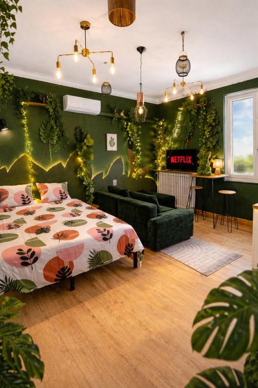 a bedroom with a bed and a green wall with plants at Le Studio Jungle climatisé in Graulhet