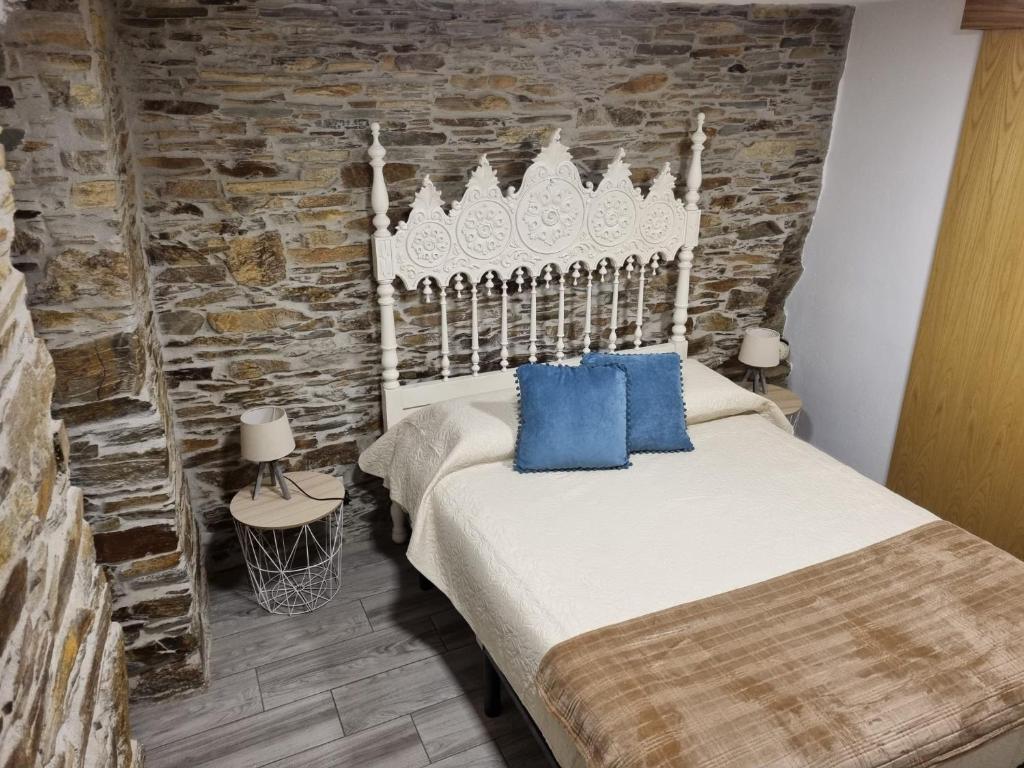 a bedroom with a bed and a stone wall at Casa da Eira in Arganil