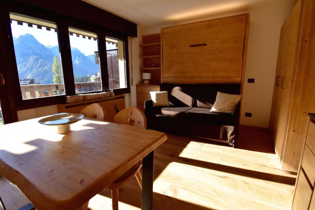 a living room with a table and a couch at Presanella View Studio Mhd in Madonna di Campiglio