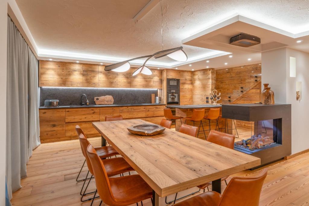 a kitchen with a wooden table and chairs at BRENTA ALTA ALPINE LODGE MhD in Madonna di Campiglio
