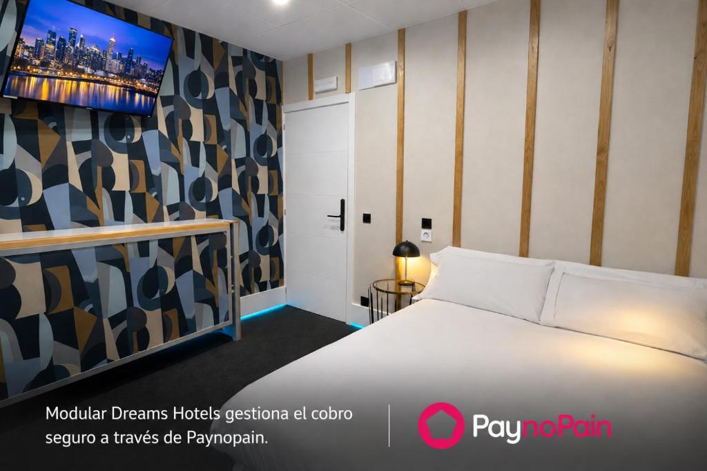 a bedroom with a bed and a tv on a wall at Modular Dreams in Madrid