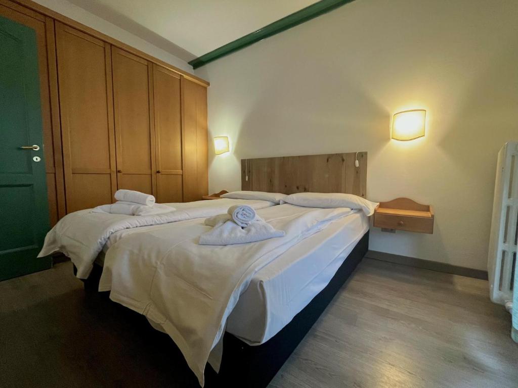a bedroom with two beds with towels on them at Central SPORT CAMPIGLIO 407 in Madonna di Campiglio