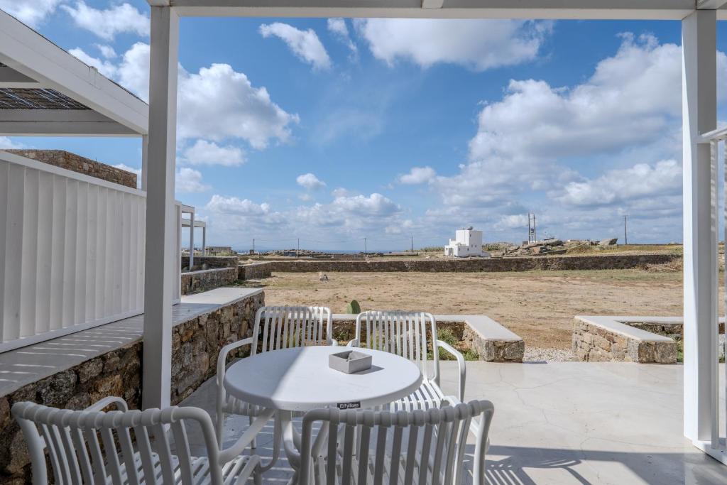 a patio with a table and chairs and a view of the beach at Jo&Co Mykonos Nature Suites N3 in Plintri