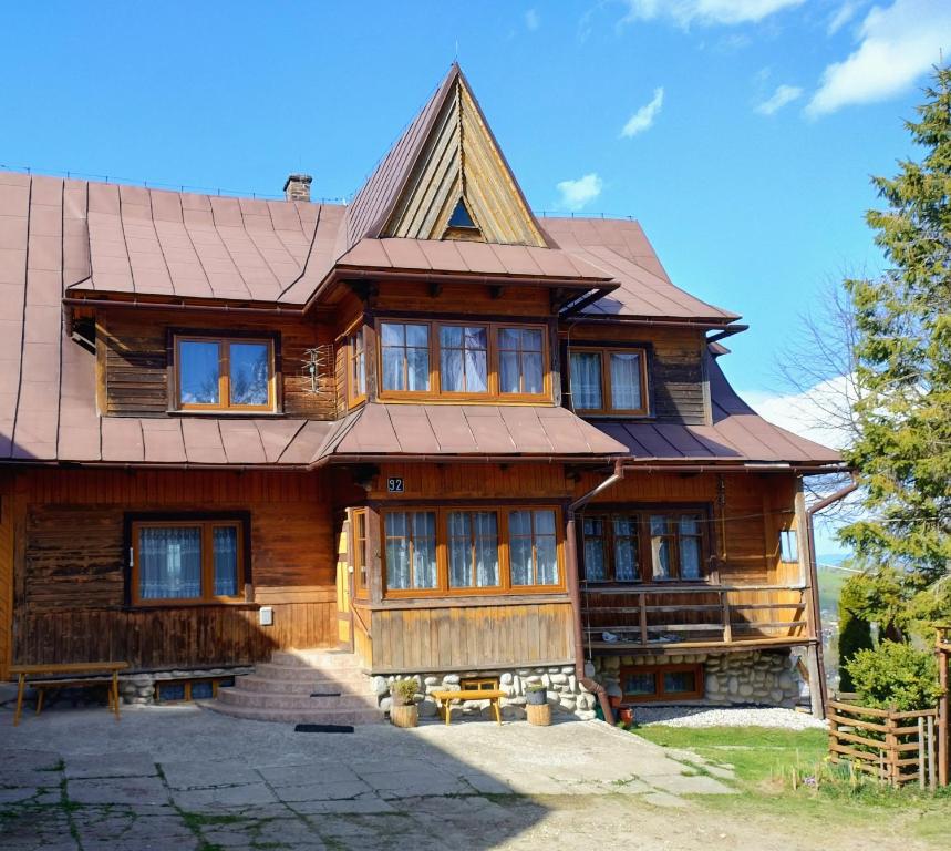 a large wooden house with a metal roof at Halne Izby - Pokoje Gościnne in Ząb