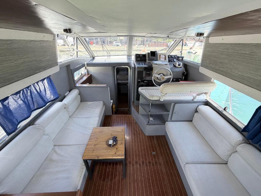 a small boat with white seats and a table in it at Confortable Yatch in Barcelona