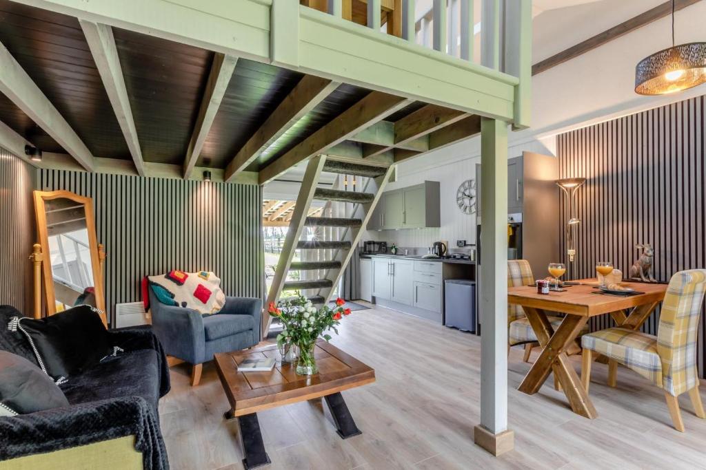 a living room with a spiral staircase and a table at 1 Bed in Tilbrook oc-a40241 in Tilbrook
