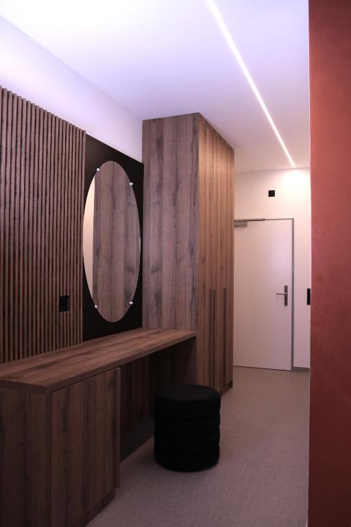 a bathroom with a mirror on the wall and a stool at Rhein Suites in Eiken