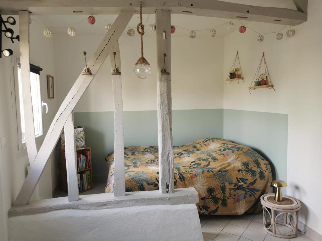 a bedroom with a bed and a staircase at La petite FloPée in Le Mont-Saint-Adrien