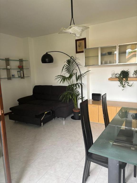 a living room with a black couch and a table at Como Gate - 10 minuti dal centro in Lucino