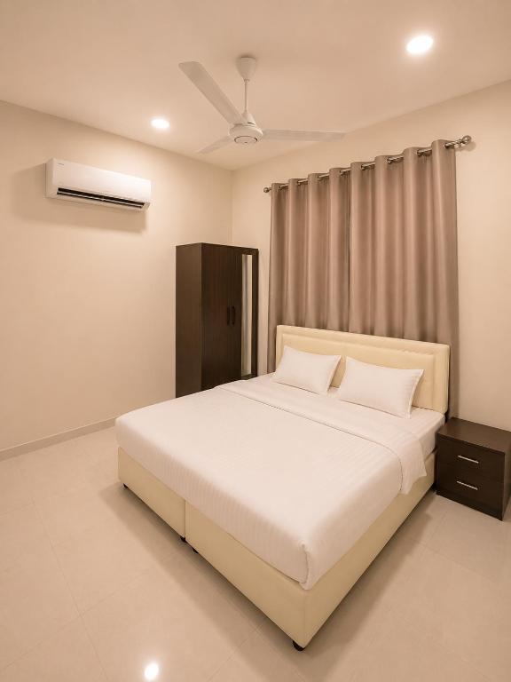 a bedroom with a white bed and a window at RED algarbeia in Salalah