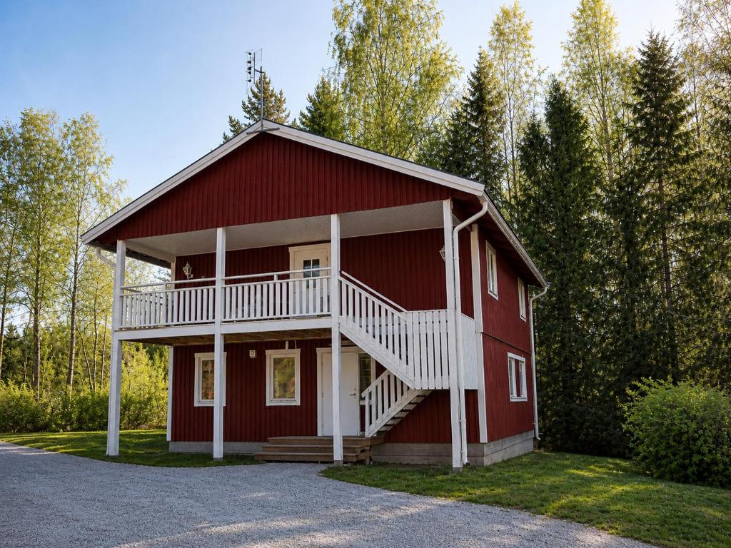 a red house with a balcony on the side of it at Solbacka apartments Norr - Panorama view in Södra Ås