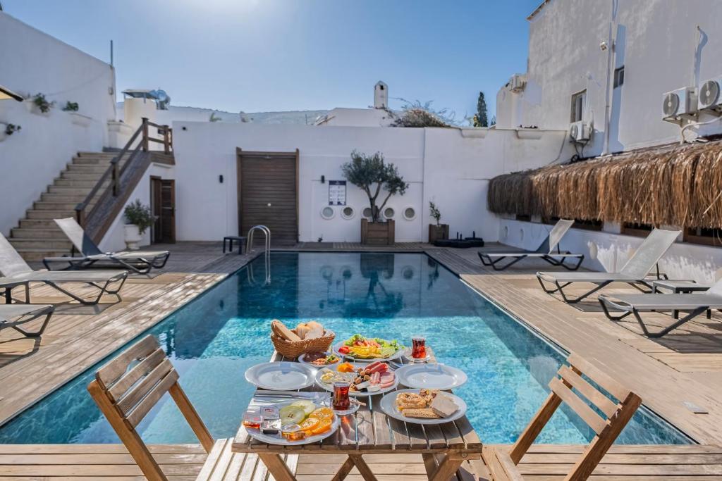 a table with food on it next to a swimming pool at Costa Viva Bodrum in Bodrum City