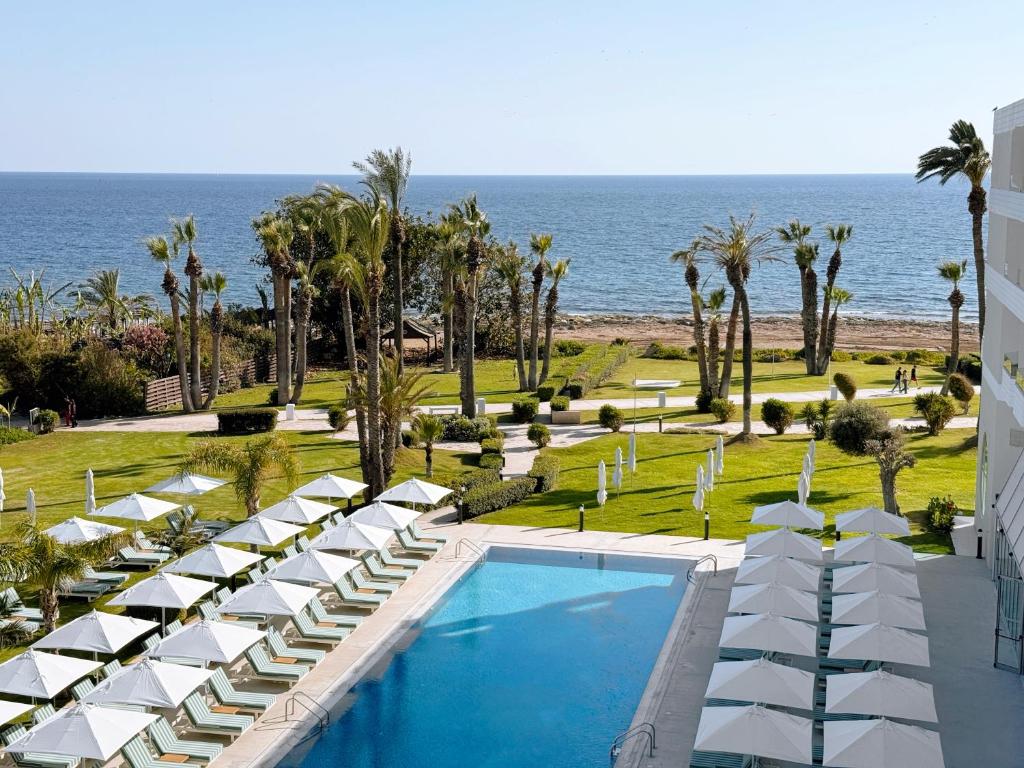 a view of a resort with a swimming pool and the ocean at Imperial Island by Louis Hotels in Yeroskipou