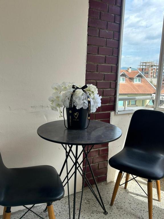 a table with a vase of flowers on it at Central apartment 4 in Gnjilane