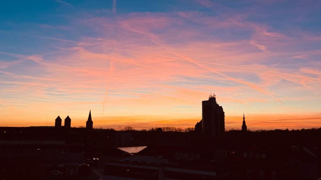 a view of a city skyline at sunset at City Apartments Osnabrück - Balkon & Parken inklusive in Osnabrück