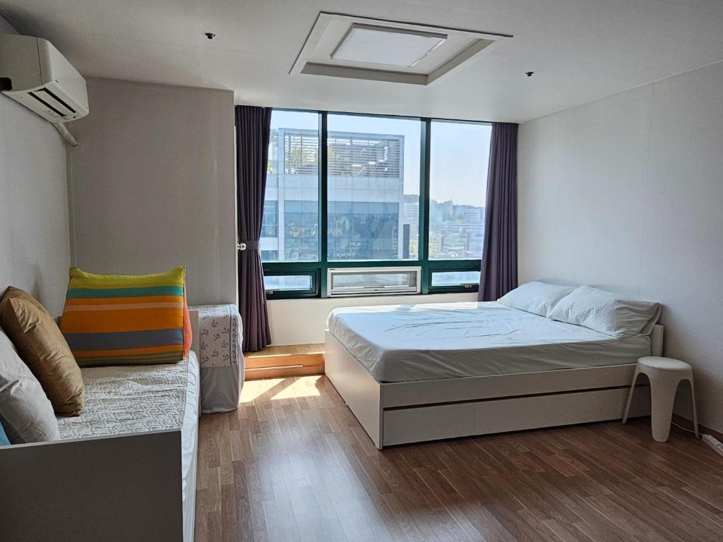 a bedroom with a bed and a large window at Hongdae Penthouse in Seoul