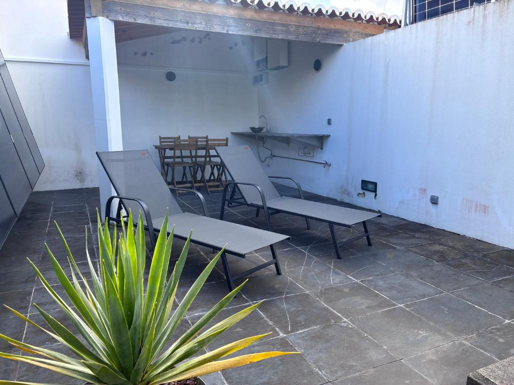 a group of tables and chairs in a room with a plant at A Casinha in Angra do Heroísmo