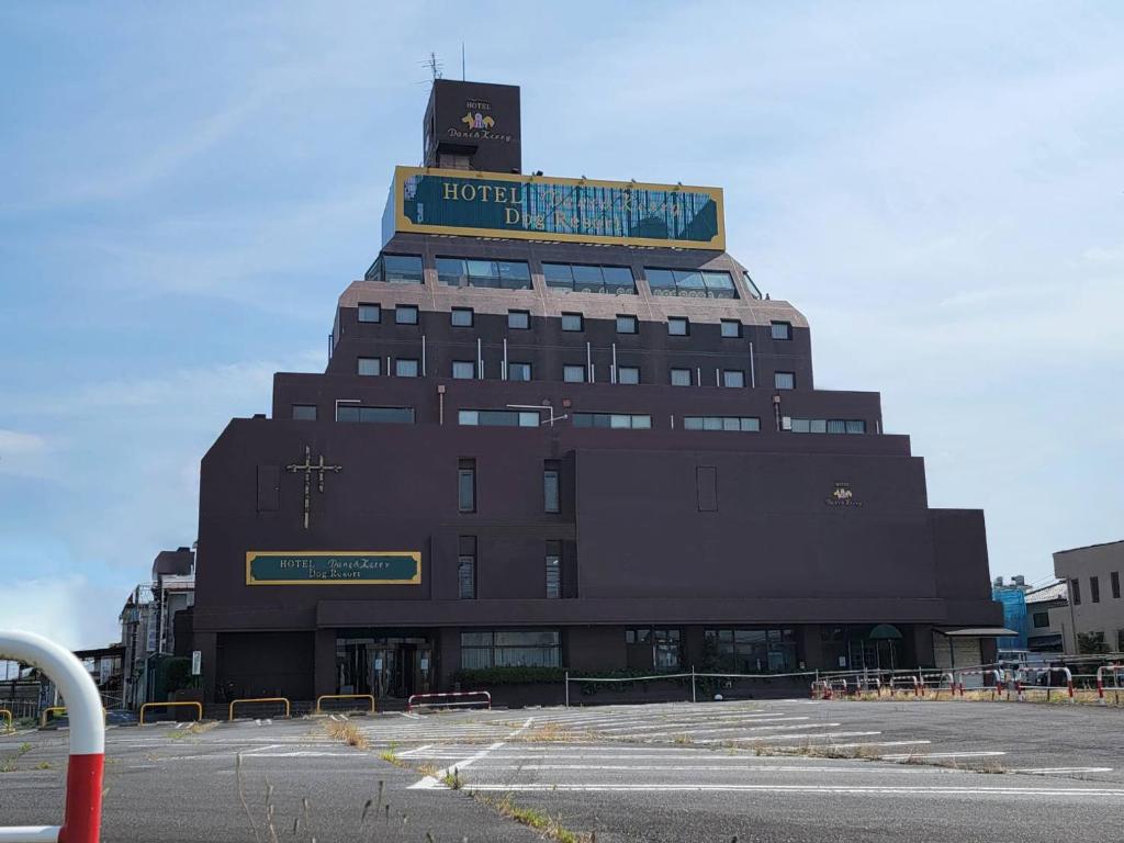 a hotel building with a sign on top of it at HOTEL Dane&Kerry DogResort in Ishioka