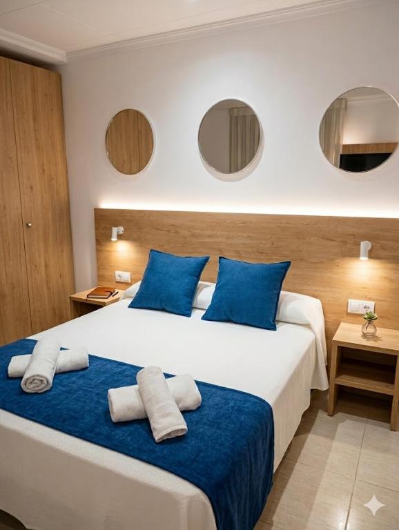 a hotel room with a large bed with blue pillows at Hotel Iberflat Marynton in Benicarló