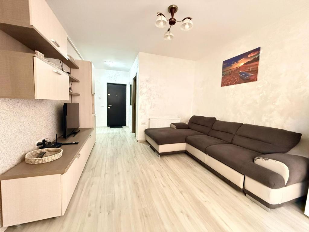 a living room with a black couch and a television at Holidays Summer Vibes Apart Mamaia Nord in Năvodari
