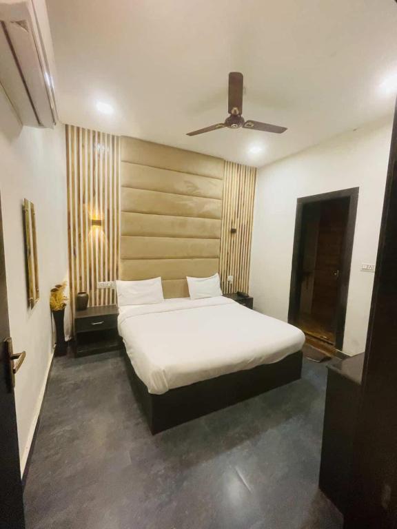 a bedroom with a white bed with a ceiling at VT residency in Tājganj