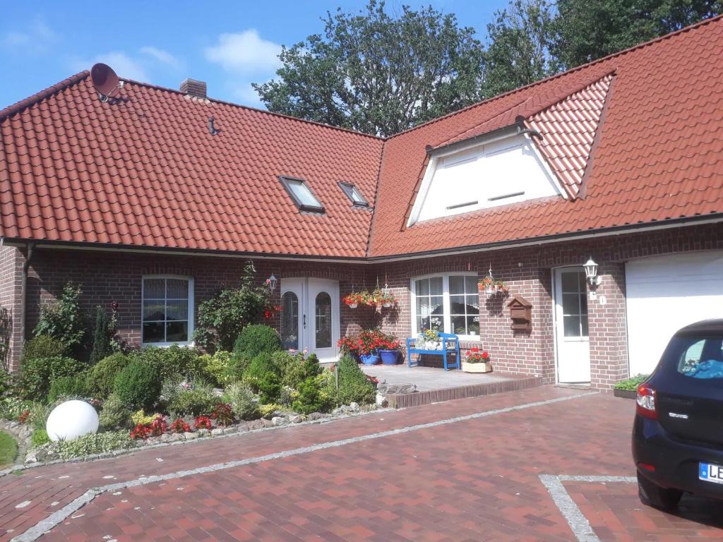 a brick house with a red roof at Ferienwohnung Ewen 55038 in Filsum