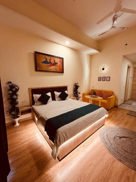 a bedroom with a large bed and a couch at THE CITYLIGHTS STAY Gaur City Mall in Ghaziabad