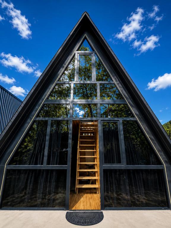 a window in the roof of a house with a ladder at Chalet Adjara in Okʼropilauri