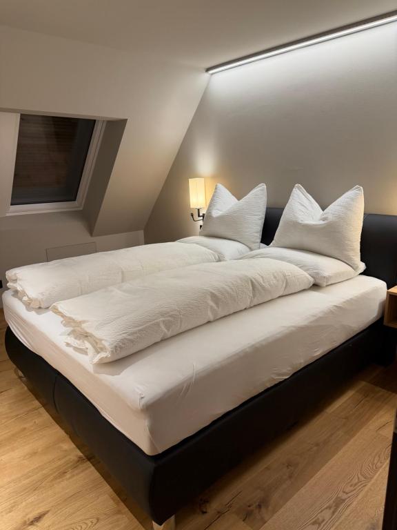 a large white bed with white pillows on it at Elsers Nummer12 in Weilheim an der Teck