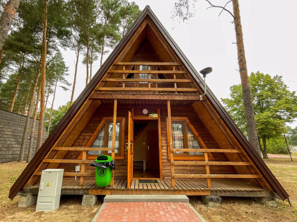 a frame house with a green vase in front of it at Przygoda nad Wartą in Burzenin
