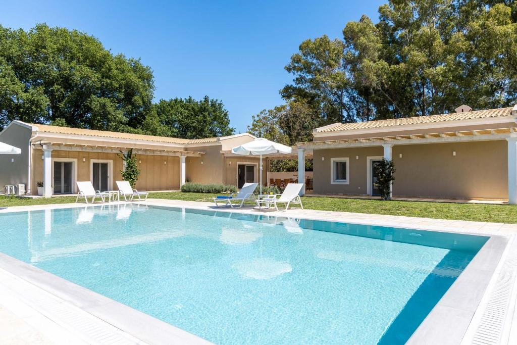 a swimming pool in front of a house at Villa Botanica in Kassiopi