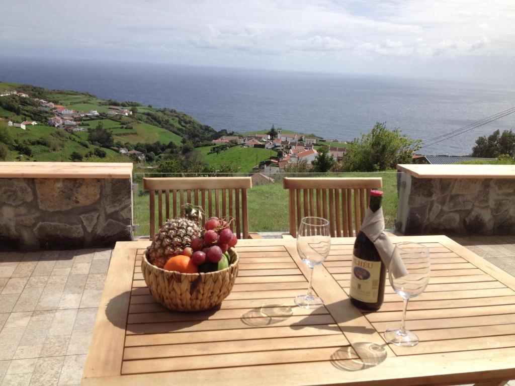 a table with a basket of fruit and a bottle of wine at CasaBelaVista II in Pedreira