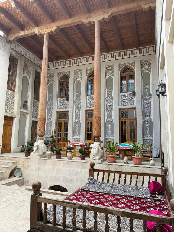 a bench in front of a building with columns at SHoxtut INN 18-19Th Century in Bukhara