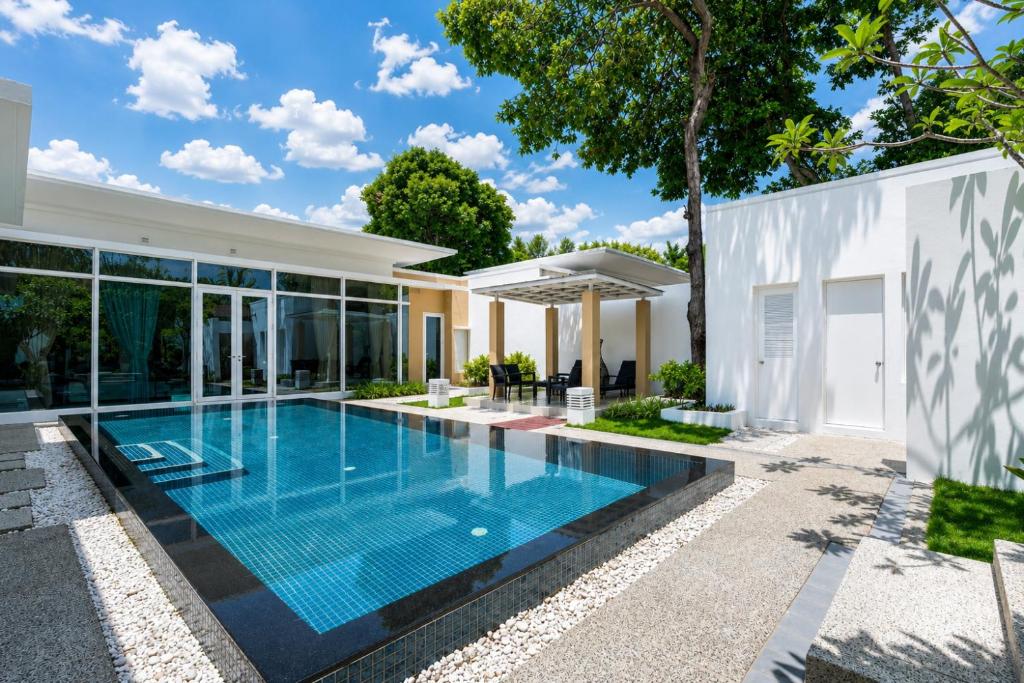 a swimming pool in the backyard of a house at Sunshine Beach Villa Mai Khao in Mai Khao Beach