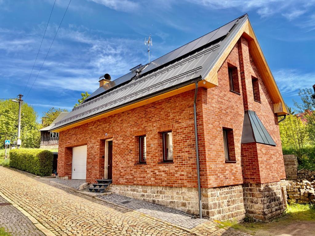 a red brick building with a black roof at Apartmán v Dráze in Zásada
