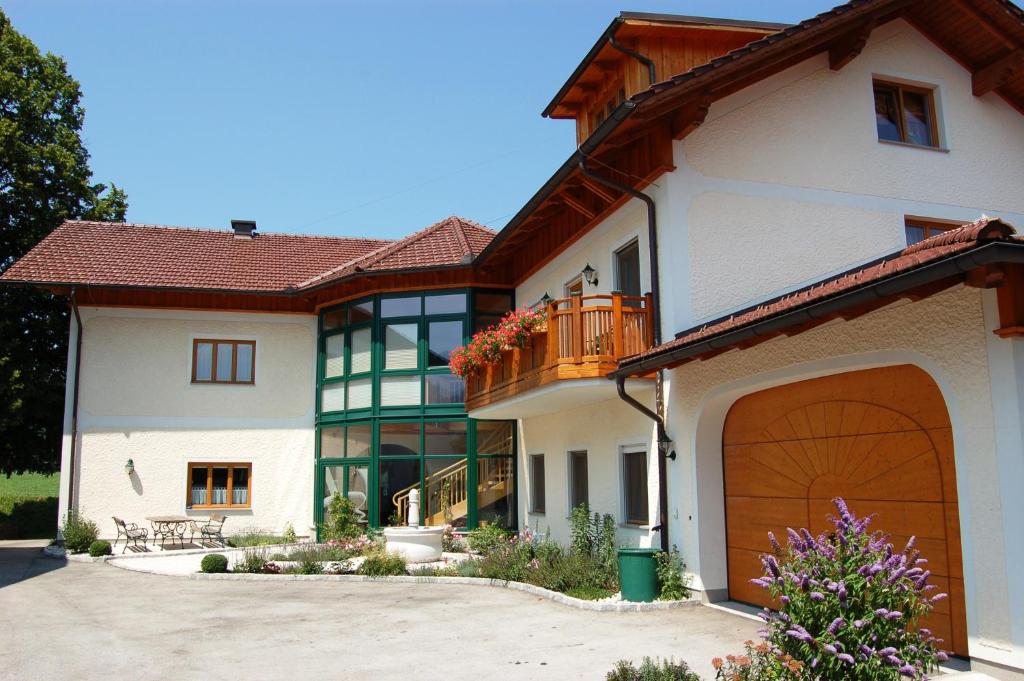 ein großes weißes Haus mit einer braunen Garage in der Unterkunft Lehnerhof in Grossraming