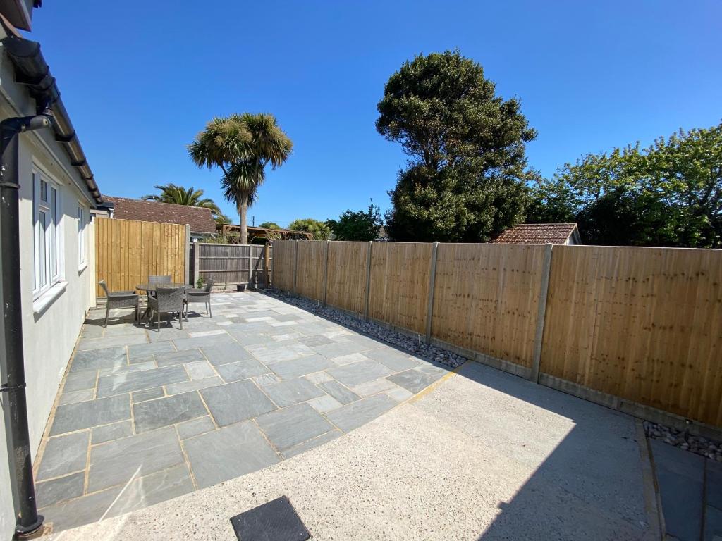 a backyard with a wooden fence and a patio at Home in Greatstone in Greatstone