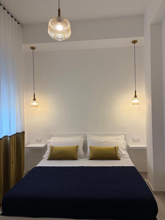 a bedroom with a large bed with two yellow pillows at Trapani Urban Nest in Trapani