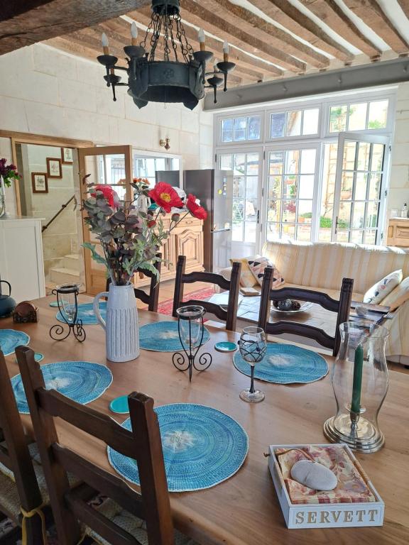 a dining room table with a vase of flowers on it at Chambre d'hotes de l'Ecu in Preuilly-sur-Claise