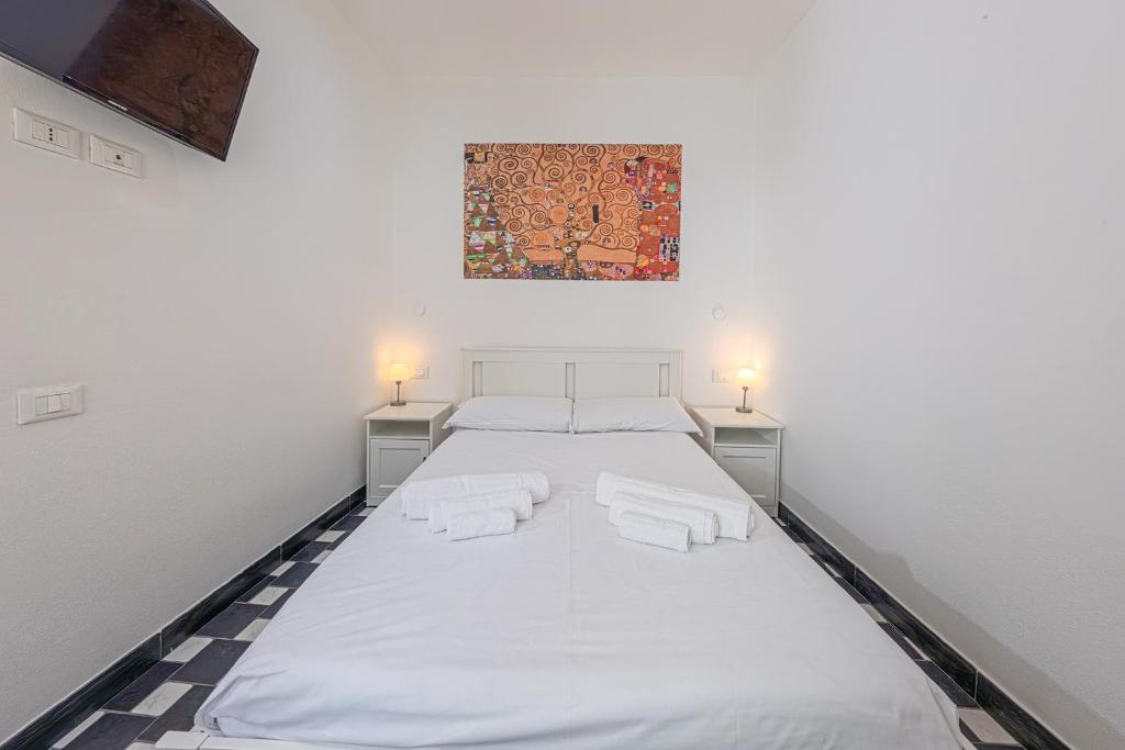 ein großes weißes Bett in einem Zimmer mit zwei Lampen in der Unterkunft Da Tallolo in Cagliari