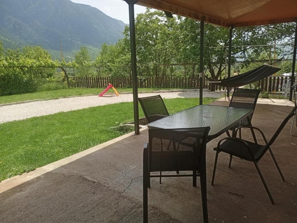 a table and chairs under an umbrella with a playground at Gamila Sunrise in Konitsa