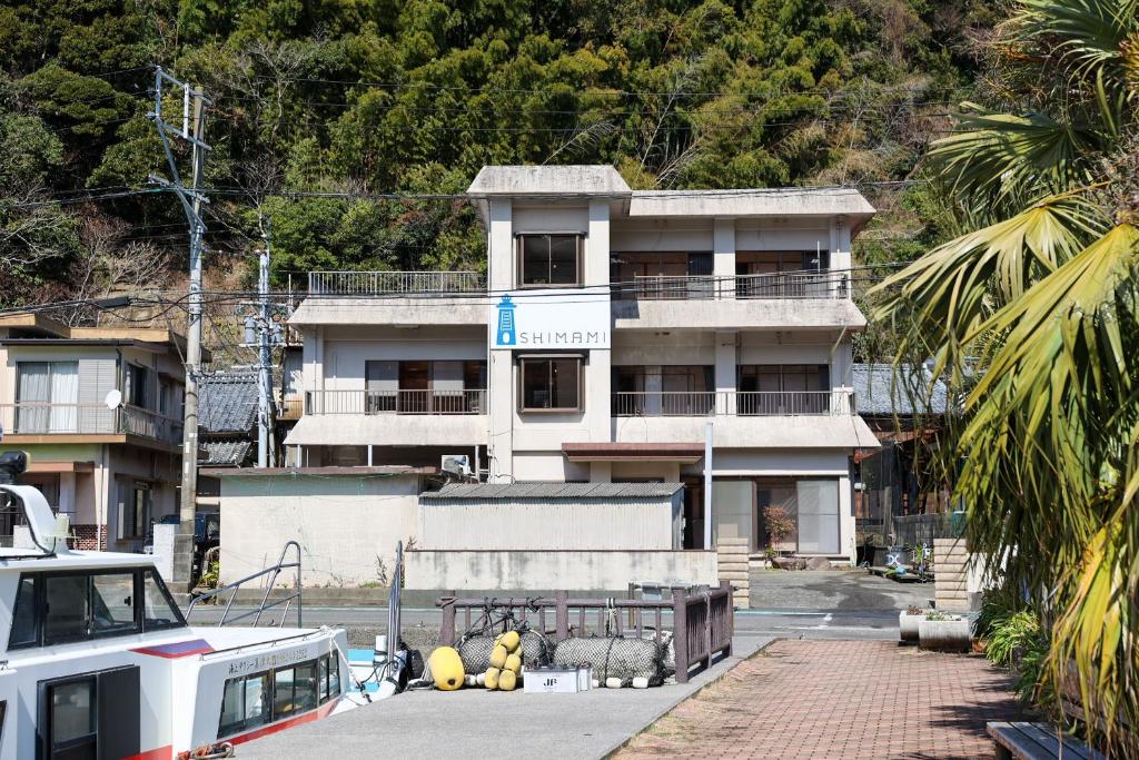 an apartment building with a parking lot in front of it at Island Base Shimami in Nobeoka