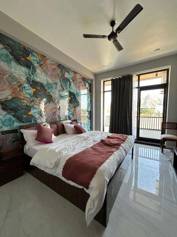 a bedroom with a large bed with a painting on the wall at Hotel Pushkar Pulse in Pushkar