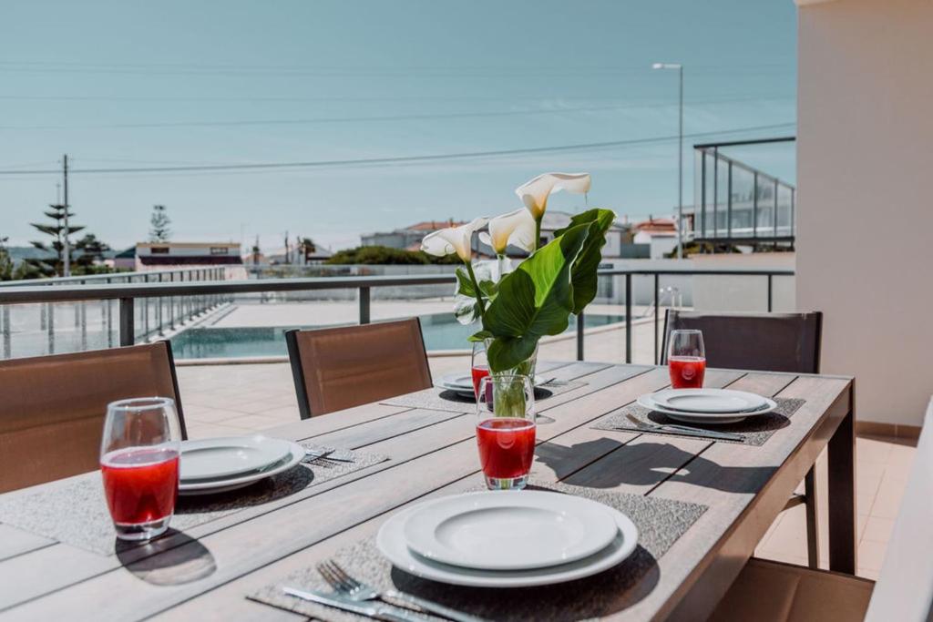 a wooden table with plates and a vase of flowers at Apartment - Casa Andres in Salir de Porto