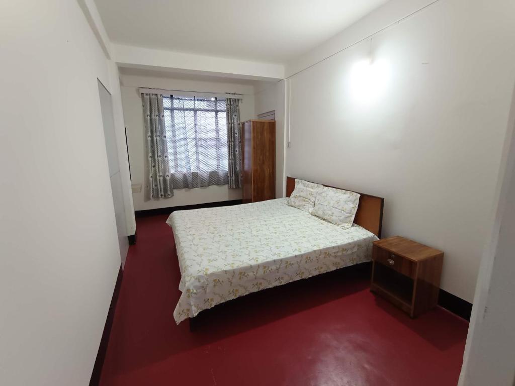 a small bedroom with a bed and a window at LeeZaiah in Shillong