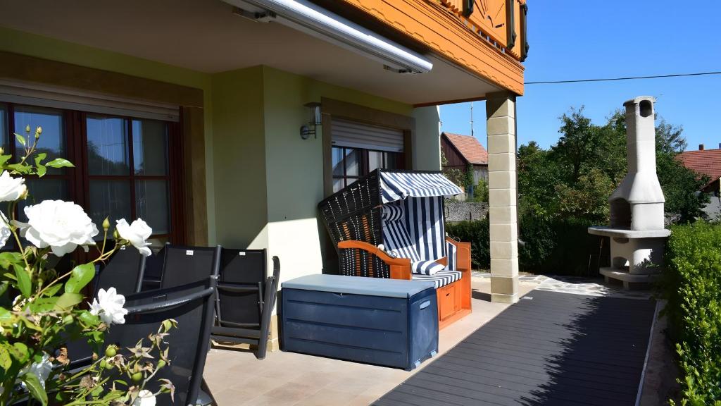 a porch with a blue chair and a fireplace at Ferienwohnung Kohler - Königsfeld in Königsfeld