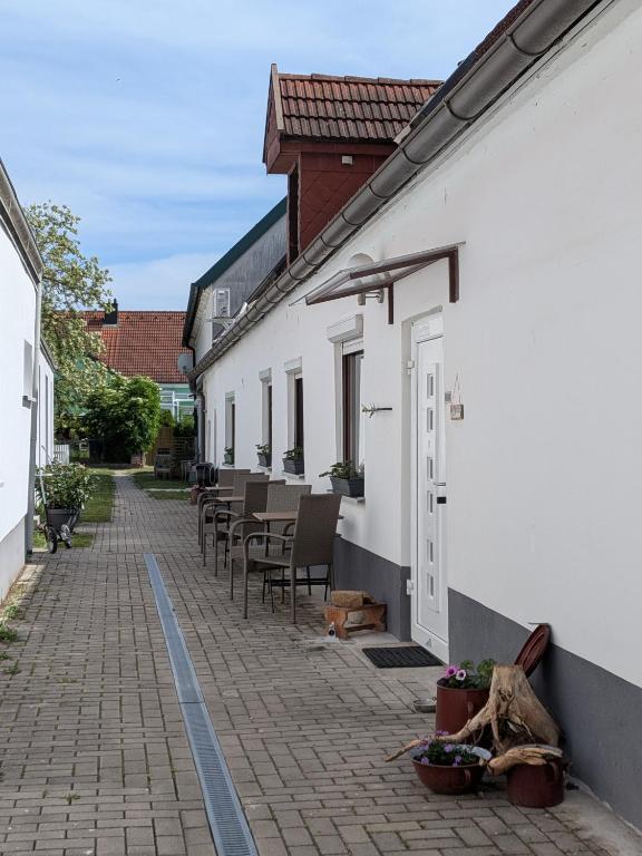an alley with tables and chairs in a white building at Lindo - Historisches Hof-Juwel in Schützen am Gebirge