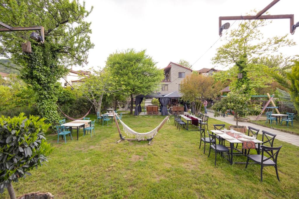 an outdoor patio with tables and chairs and hammocks at Hedi in Mtskheta
